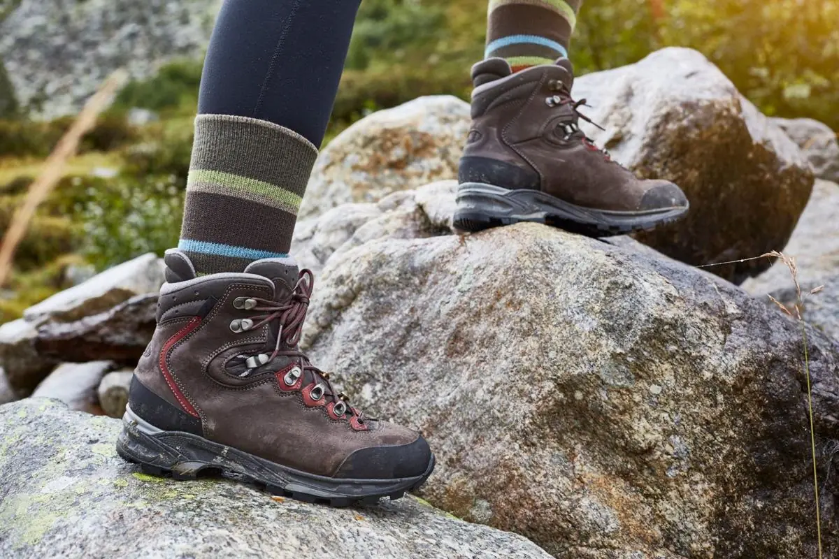 Braune Lederbergstiefel mit Wandersocken auf Granitfelsen